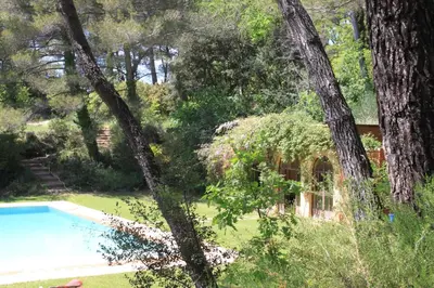 a house in the woods with a swimming pool and trees at La Petite Yolande in Aix-en-Provence