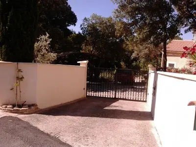 a white fence with a gate in front of a house at Les Florides in LʼIsle-sur-la-Sorgue