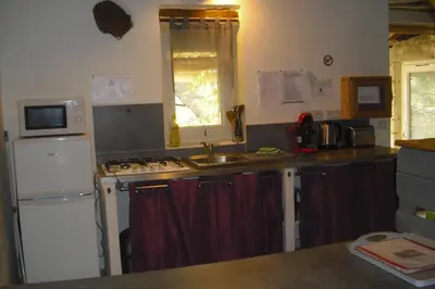 a small kitchen with a sink and a refrigerator at Lou mas li Pitchoun 