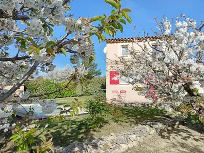 a house with a flowering tree in front of a building at Le Petit Mas des Hauts de Beyssan, Maison de vacances avec piscine privative pour 2 personnes in Gargas
