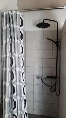 a shower with a black and white shower curtain at Le Petit Mas des Hauts de Beyssan, Maison de vacances avec piscine privative pour 2 personnes in Gargas