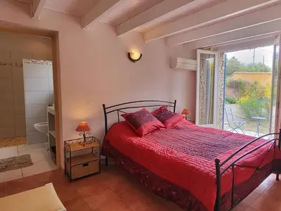 a bedroom with a bed with red sheets and a window at Sunny Provence Getaway in Villes-sur-Auzon