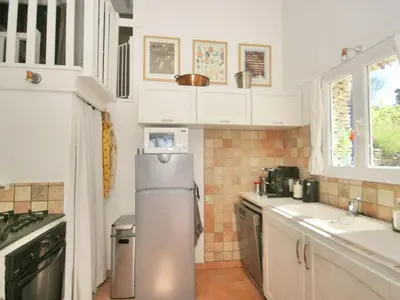 a kitchen with white cabinets and a stainless steel refrigerator at Sunny Provence Getaway in Villes-sur-Auzon
