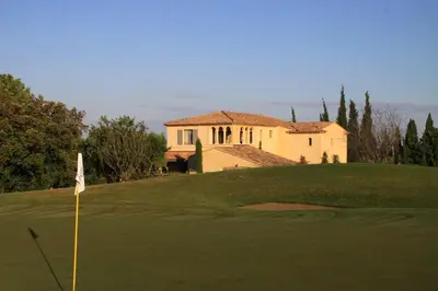 a golf course with a house in the background at Villa Briali Pont Royal in Mallemort