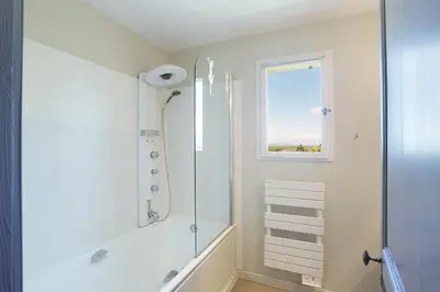 a white bathroom with a shower and a window at Villa Briali Pont Royal in Mallemort