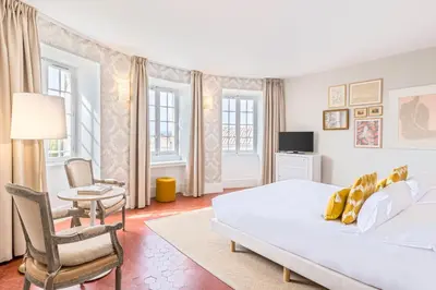 a bedroom with a bed and a table and chairs at Château de Mazan - Handwritten Collection in Mazan