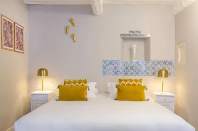 a bedroom with a large white bed with yellow pillows at Château de Mazan - Handwritten Collection in Mazan
