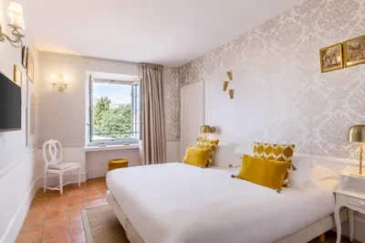 a bedroom with a large white bed with yellow pillows at Château de Mazan - Handwritten Collection in Mazan