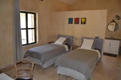 a bedroom with two beds and a window at Mas Ste Hélène in Céreste