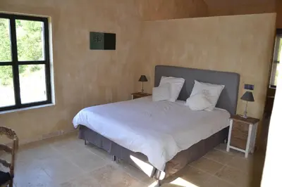 a bedroom with a large bed with white sheets and pillows at Mas Ste Hélène in Céreste
