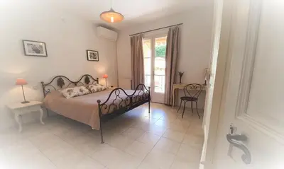 a bedroom with a bed and a table and a window at Côté Provence in Le Thor