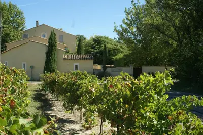 a house and a row of bushes in front of a building at Côté Provence in Le Thor