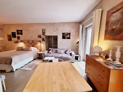 a bedroom with a bed and a couch at Le Mas Des Bardes in Pernes-les-Fontaines