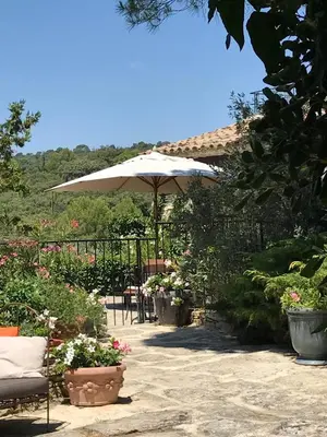 a patio with an umbrella and some plants and flowers at La Borie en Provence in Gordes
