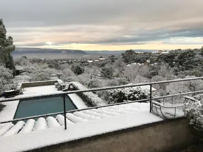 a snow covered balcony with a view of a city at La Borie en Provence in Gordes