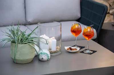a table with two wine glasses and candles on it at Domaine la Pierre Blanche in Eygalières