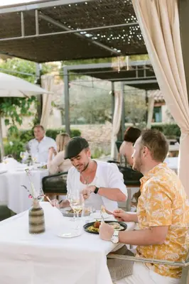 a group of men sitting at a table eating food at Domaine la Pierre Blanche in Eygalières
