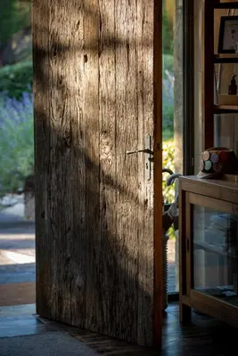 a wooden door in a room with a table at Domaine la Pierre Blanche in Eygalières