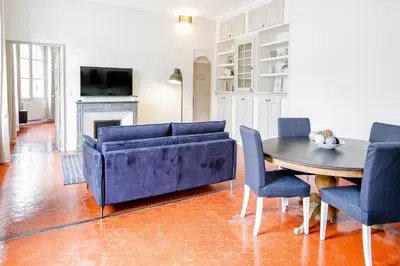 a living room with a blue couch and a table at L'Oustau D'Alberta in Aix-en-Provence