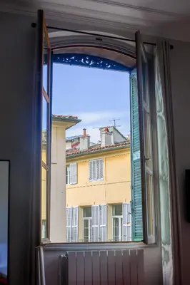 an open window with a view of a building at L'Oustau D'Alberta in Aix-en-Provence