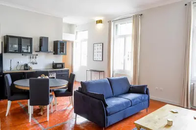 a living room with a blue couch and a table at L'Oustau D'Alberta in Aix-en-Provence