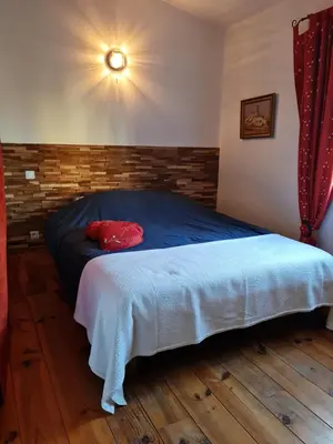 a bedroom with a bed with a red pillow on it at Petit gite de Provence in Mazan