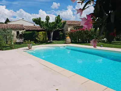 a swimming pool in front of a house at Petit gite de Provence in Mazan