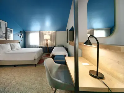 a living room with a green couch and chairs at Radisson Hotel Aix En Provence in Aix-en-Provence