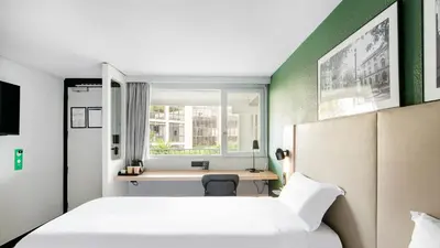 a bedroom with a bed and a desk and a window at Campanile Prime - Aix-en-Provence Sud - Pont de l'Arc in Aix-en-Provence