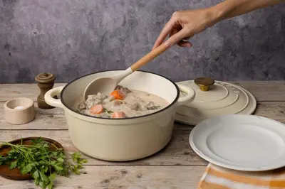a person stirring a pot of soup with a wooden spoon at Campanile Prime - Aix-en-Provence Sud - Pont de l'Arc in Aix-en-Provence