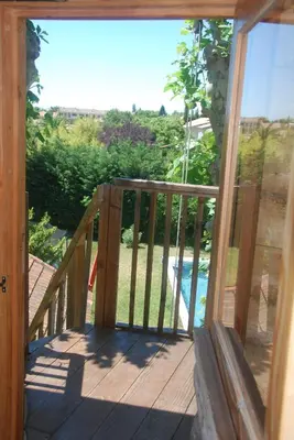 a wooden balcony with a view of a pool at Les Volets Bleus Provence in Salon-de-Provence