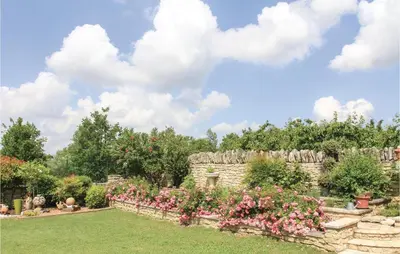a stone wall with flowers in a garden at 3 Bedroom Stunning Home In Gordes in Gordes