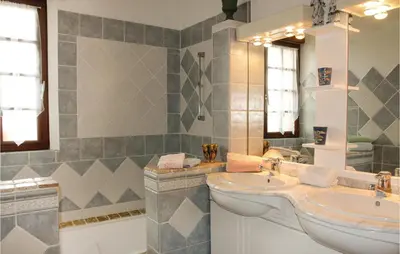 a bathroom with two sinks and a mirror at 3 Bedroom Stunning Home In Gordes in Gordes