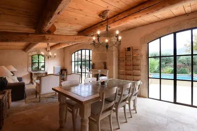 a dining room with a large wooden table and chairs at Domaine Les Roullets in Oppède