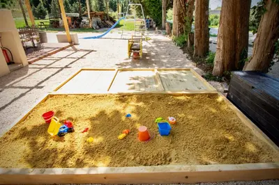 a sandbox with toys in the sand in a park at La Maison du Moulin de Tartay in Avignon