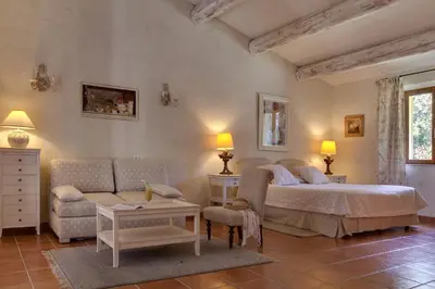 a bedroom with a bed and a couch and a table at Hôtel Restaurant Mas de Fauchon - Teritoria in Saint-Cannat
