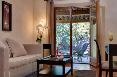 a living room with a couch and a table at Hôtel Restaurant Mas de Fauchon - Teritoria in Saint-Cannat