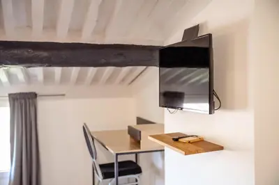 a room with a desk and a tv on the wall at Appart Hypercentre CLIM 2chb QuartierChic in Aix-en-Provence