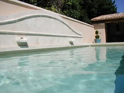 a swimming pool with blue water in a house at Chambre d'hôte Anais in Eyguières