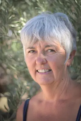 an older woman with grey hair is smiling at Que Passion in Blauvac