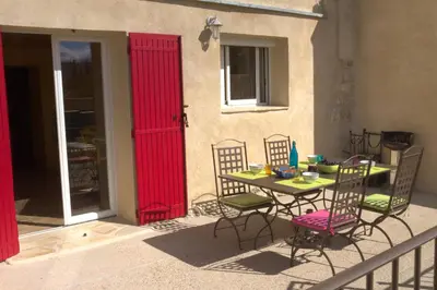 a table and chairs on a balcony with a red door at Que Passion in Blauvac