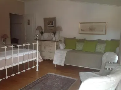 a living room with a bed and a crib at Le petit Figuier in La Roque-dʼAnthéron