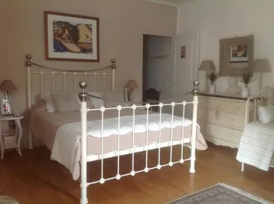 a bedroom with a white bed and a dresser at Le petit Figuier in La Roque-dʼAnthéron