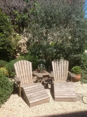 two chairs and a table in a garden with a table and sidx sidx at Le petit Figuier in La Roque-dʼAnthéron