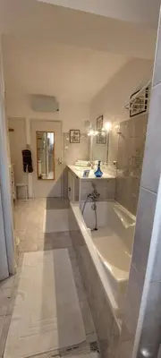 a large bathroom with a tub and a tile floor at La maisonnette in Crillon-le-Brave