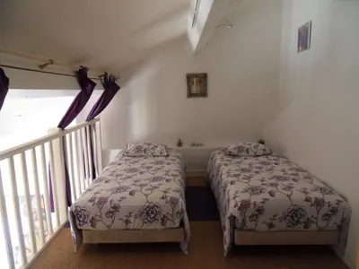 two beds in a small room with a staircase at Domaine de L'Olibaou in Venelles