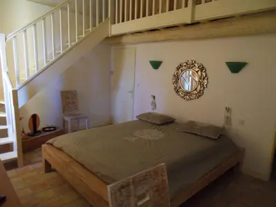 a bedroom with a large bed with a staircase at Domaine de L'Olibaou in Venelles