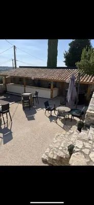 a patio with chairs and tables and a building at Domaine de L'Olibaou in Venelles