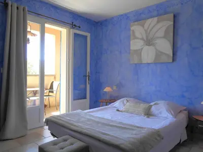 a bedroom with blue walls with a bed and a window at Clos des Lavandes - Chambres et Suites de charme climatisées-Luberon in Lacoste