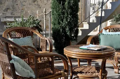 a patio with wicker chairs and a table at Le Petit Chateau in Châteauneuf-de-Gadagne